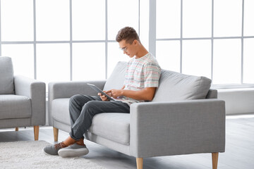 Fototapeta premium Teenage boy with tablet computer at home