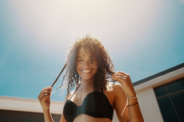 Young African woman in bikini enjoying summer weather at the pool