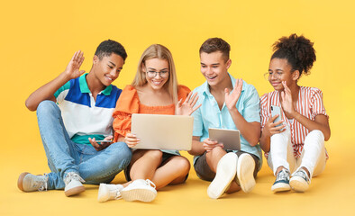 Teenagers with different devices video chatting on color background