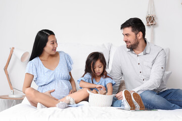 Pregnant Asian woman with her family at home
