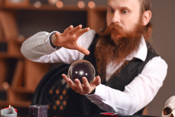 Male fortune teller with crystal ball reading future