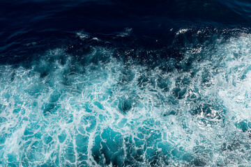 Rough deep turquoise and dark blue pacific sea with white foam texture background.	