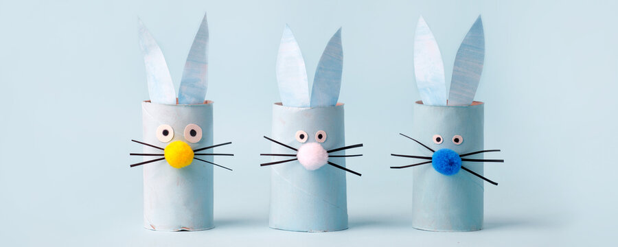 Set of Paper bunny rabbit for Happy Easter seasonal party. Easy craft for kids on blue background, simple diy idea from toilet rool tube, recycle concept, copy space, coupon, flyer, banner