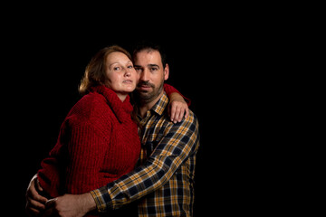 Middle-aged couple with attitude of love posing on a black studio background