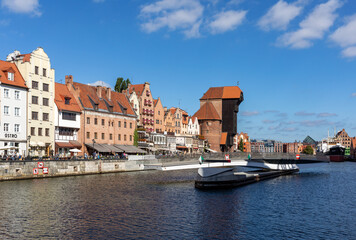 The largest medieval port Crane in Europe and historic buildings on the Dlugie Pobrzeze over the Motlawa River in Gdansk, Poland.