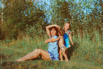 mother sitting on the grass with children