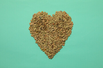 Heart made of legumes on mint background