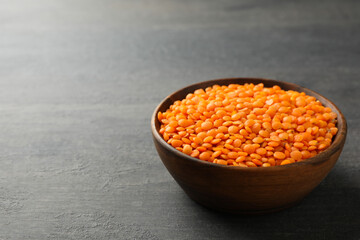 Bowl with legumes on dark wooden background, space for text