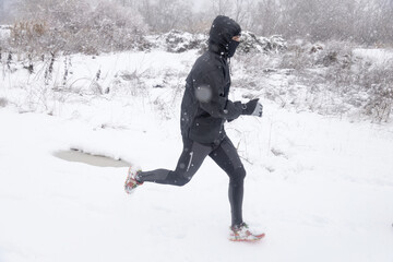 Fototapeta na wymiar man running with dog in snowy landscape