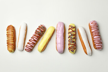 Tasty eclairs with different topping on white background