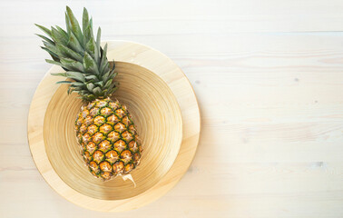whole pineapple on a plate on a white background