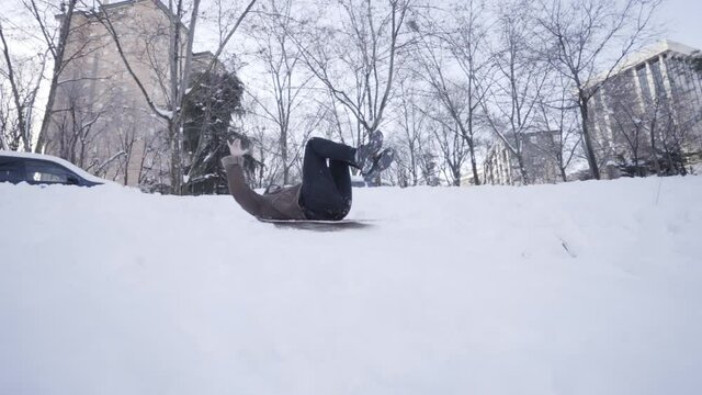 Hombre desliz&aacute;ndose por la nieve en la ciudad