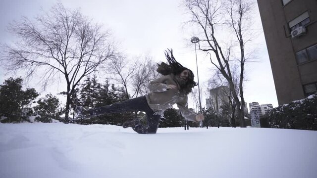 Mixed race woman jumping to the snow