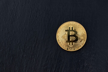 Bitcoin coin on black background, close up. Peer-to-peer payment system. Copy space