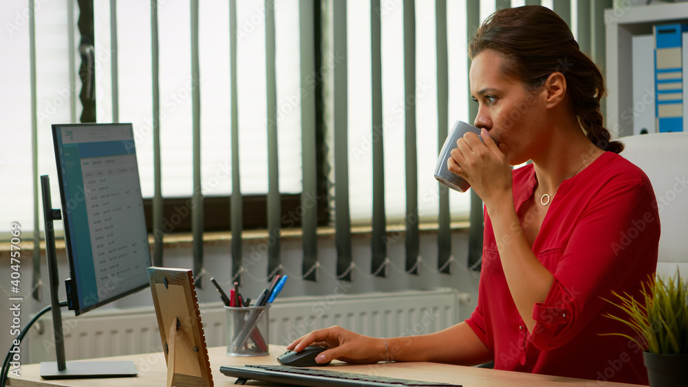 Poster freelancer drinking coffee at the office and typing at computer in special program. entrepreneur wor