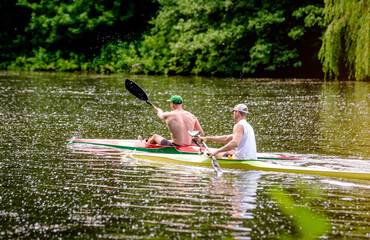 Two men floating in a canoe on the river
