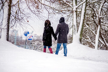 Fototapeta na wymiar A guy and a girl walking in winter Park 
