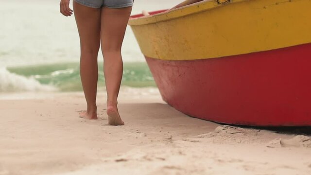 Beautiful woman walking on the beach sand barefoot