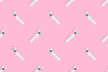 Adjustable metal wrench seamless pattern. Adjustable metal wrench on a pink background.