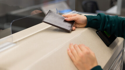 Obraz premium Faceless woman at the airport holding out passport assistant to the check-in counter.
