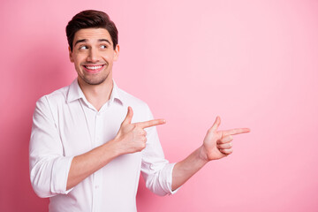 Portrait of optimistic nice guy point look empty space wear white shirt isolated on pink color...