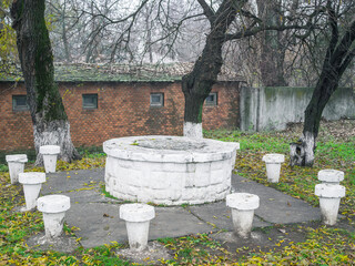 Outdoor ancient medieval stone round table with small stone made chairs.