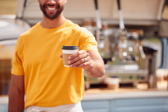 Close Up Of Man Running Mobile Coffee Shop Holding Takeaway Cup Outdoors Next To Van