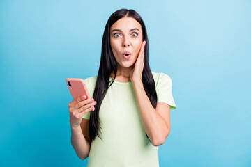 Photo portrait of impressed woman touching face cheek holding phone in one hand isolated on pastel...
