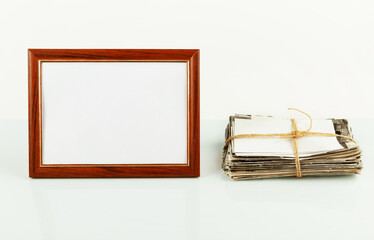  Blank photo frame for photos,, stack of old photos on the table. Mockup.