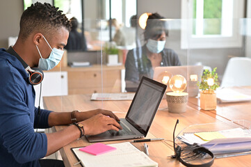 Fototapeta na wymiar Multiracial staff at work in cowork office - Young people wearing surgical mask for coronavirus