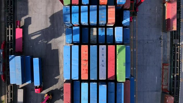 Vladivostok, Russia - Summer, 2020 - Top view. Flying over a large container warehouse at the commercial port of Vladivostok. Even rows of metal containers. Port work.