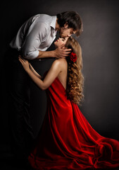 Sensual Couple Kissing in Love. Handsome Man hugging romantic Woman in red Dress. Valentines People Concept
