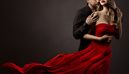 Romantic Lovers Couple Dancing. Man hugging and kissing beautiful Woman in Silk Red flying Dress. Fashion Portrait. Studio Black Background