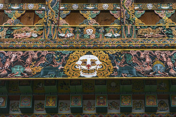 Fototapeta na wymiar Intricate and colorful traditional wood carving representing impermanence and buddhist hell in Gangtey monastery, Phobjikha valley, Bhutan