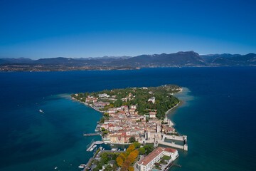 Top view of the town of Sirmione, Italy. Lake Garda, a tourist destination in northern Italy. Trees in the autumn season. Autumn in Italy on Lake Garda, Sirmione peninsula.