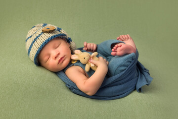 newborn baby in blue wrap and hat