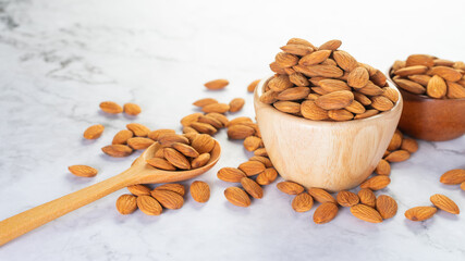 Almonds in wooden bowl with wooden spoon on the table.Healthy food Concept.