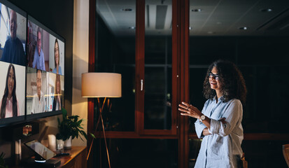 Businesswoman having a late night video call with teammates