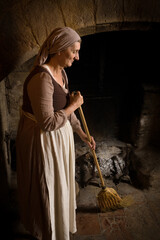 Medieval peasant woman working at fireplace