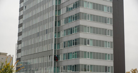 Utility climber while washing the windows of an office building