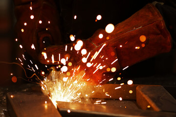 Close-up of the hands of a man who welds metal