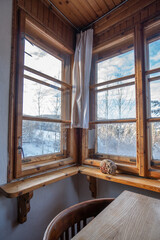 Cozy breakfast in a cabin with a window on nature, with a snowy landscape in the background, working from home, holidays and dexterity from the city, in the countryside.