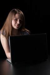 Young girl with long brown hair to the laptop