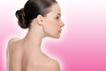 Naklejka premium Young woman with perfect healthy skin and hair in bun on a pink background with a shaded white outline