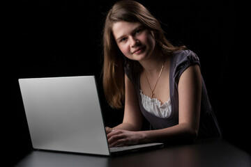 Young girl with long brown hair to the laptop