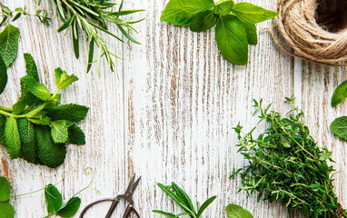 Fresh herbs and twine on wooden background top view