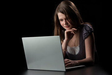 Young girl with long brown hair to the laptop