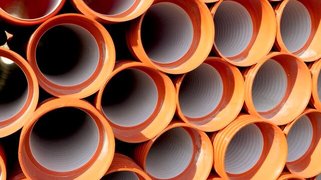 Dolly shot of pvc pipes and tubes stacked in the factory warehouse ready for transportation