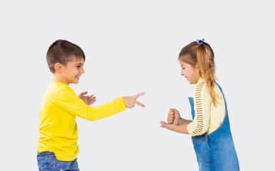 Preschool children play a game of stone, scissors, paper on a white background. Entertainment concept for children.