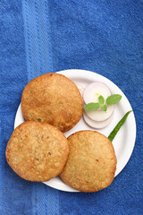 Kachori, green chilly and onion slice in plate. kachori is a spicy snack from India also spelled as kachauri and kachodi. Favorite Tea time snacks